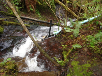 A micro-hydro intake and penstock temporarily divert a portion of the water flow and carry it to the location of the turbine. 